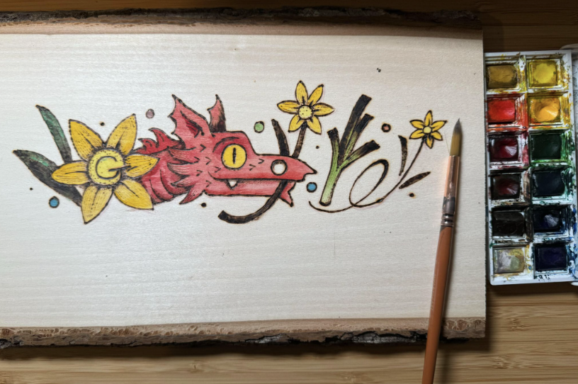 Wood slab with a color version of the Doodle artwork. Paint materials are seen on the side.