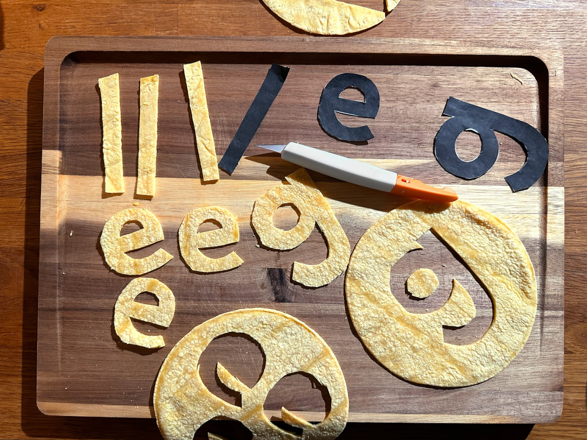 A cutting board with the Google letters cut out of pieces of a tortilla.