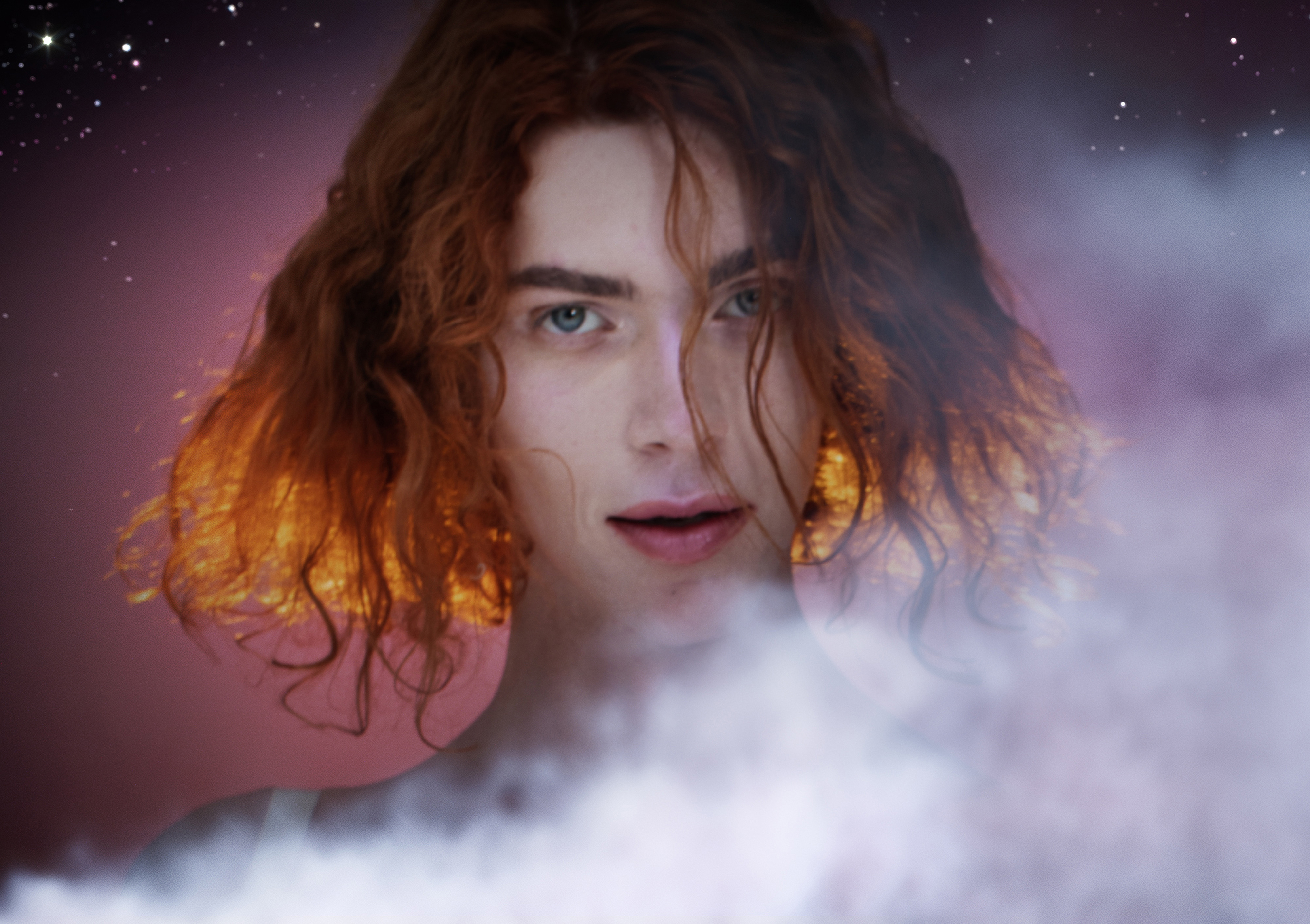 Photo of Sophie Xeon with white smoke and a starry background. She has white skin, blue eyes, and red mid-length wavy hair.