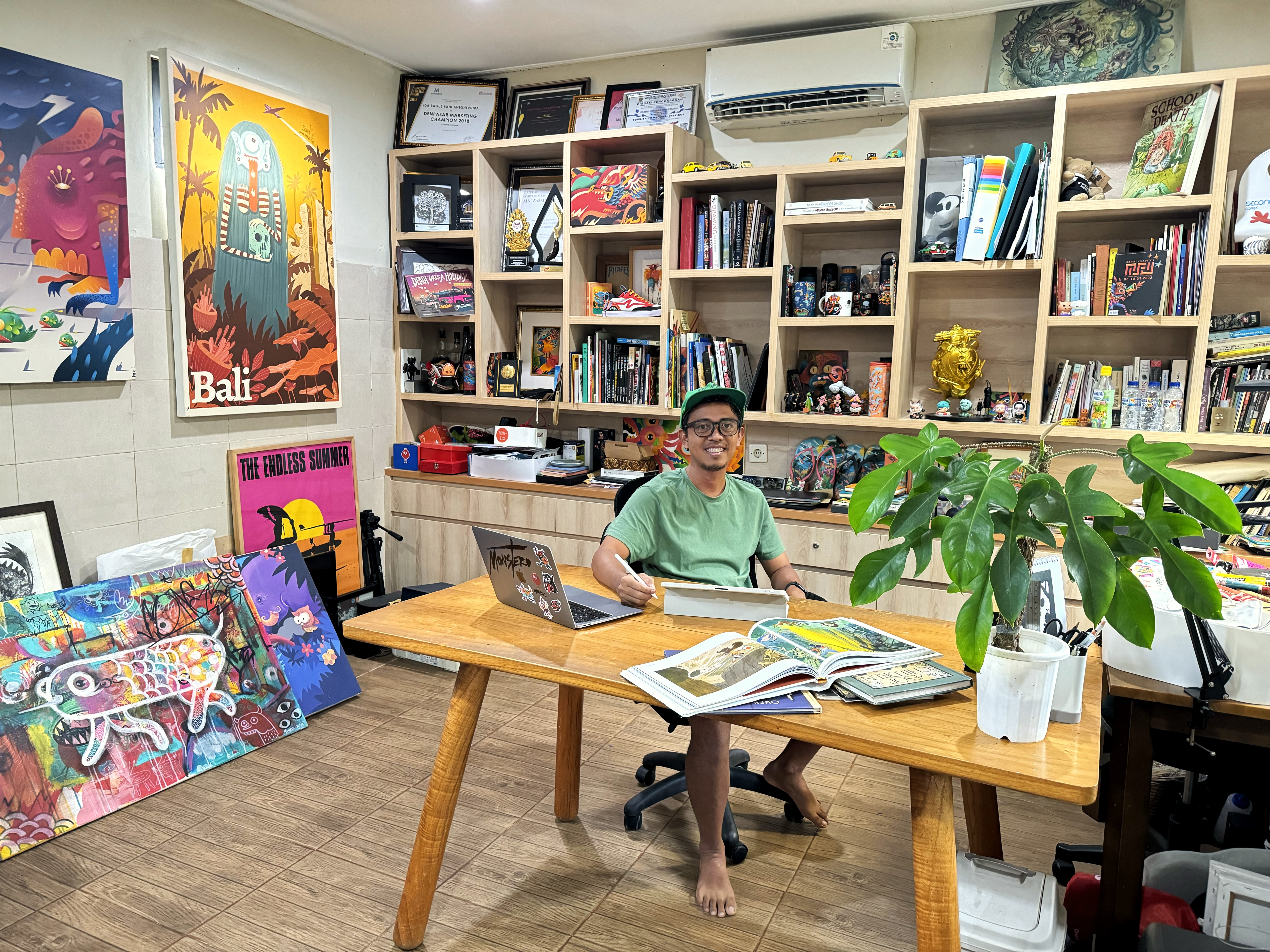 Photo of a man sitting at a desk in an art studio