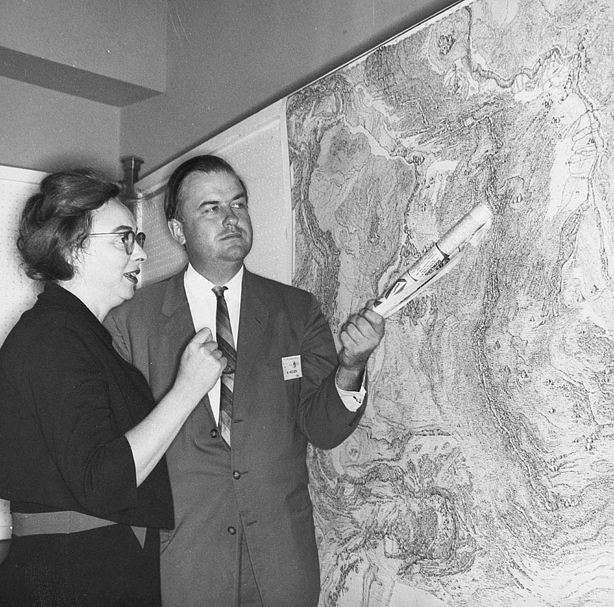 Black and white photograph of Marie Tharp and Bruce Heezen looking at a map together