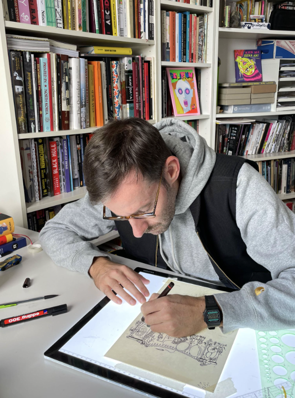 Photograph of a man drawing on a table