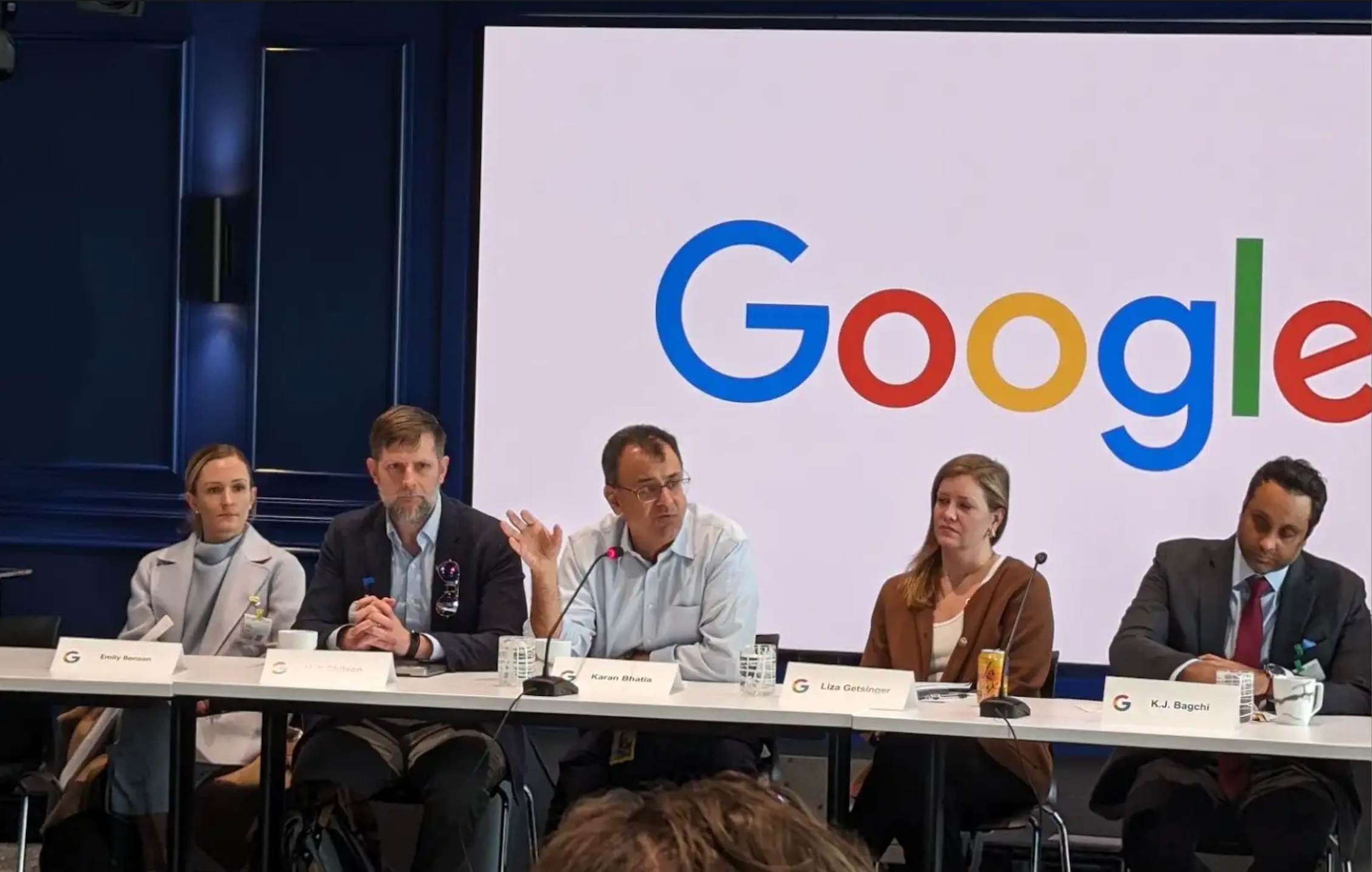 A panel of five people sitting at a table with a Google logo visible behind them 