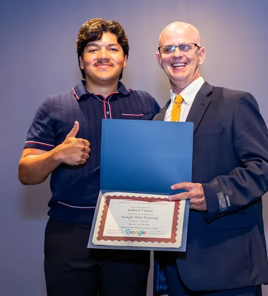 A recent Google Skilled Trades and Readiness Program graduate and program manager pose for the camera after the graduation ceremony.