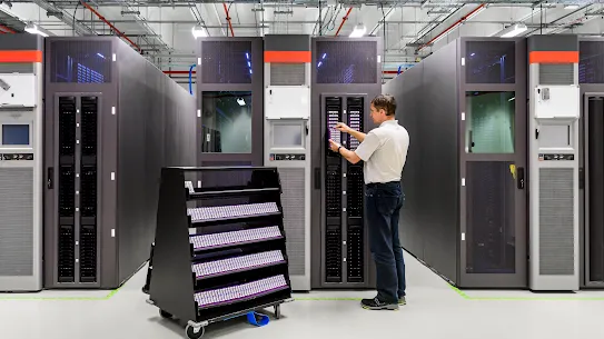 Photograph of a man adjusting a panel on a large piece of hardware.