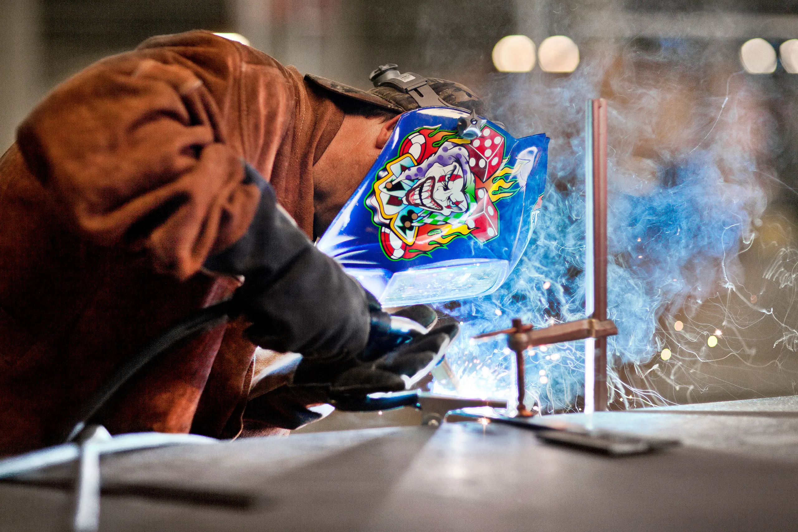 Jeff, who's an associate facilities manager in our Lenoir data center, wears a colorful welding mask while he burns some wire in a fabrication area.