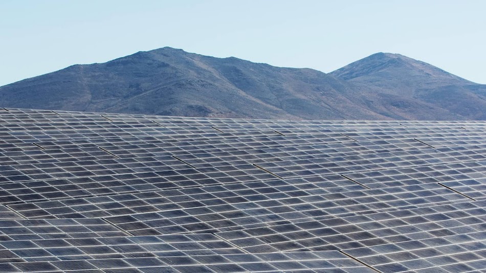 Filas de paneles solares en un paisaje desértico.