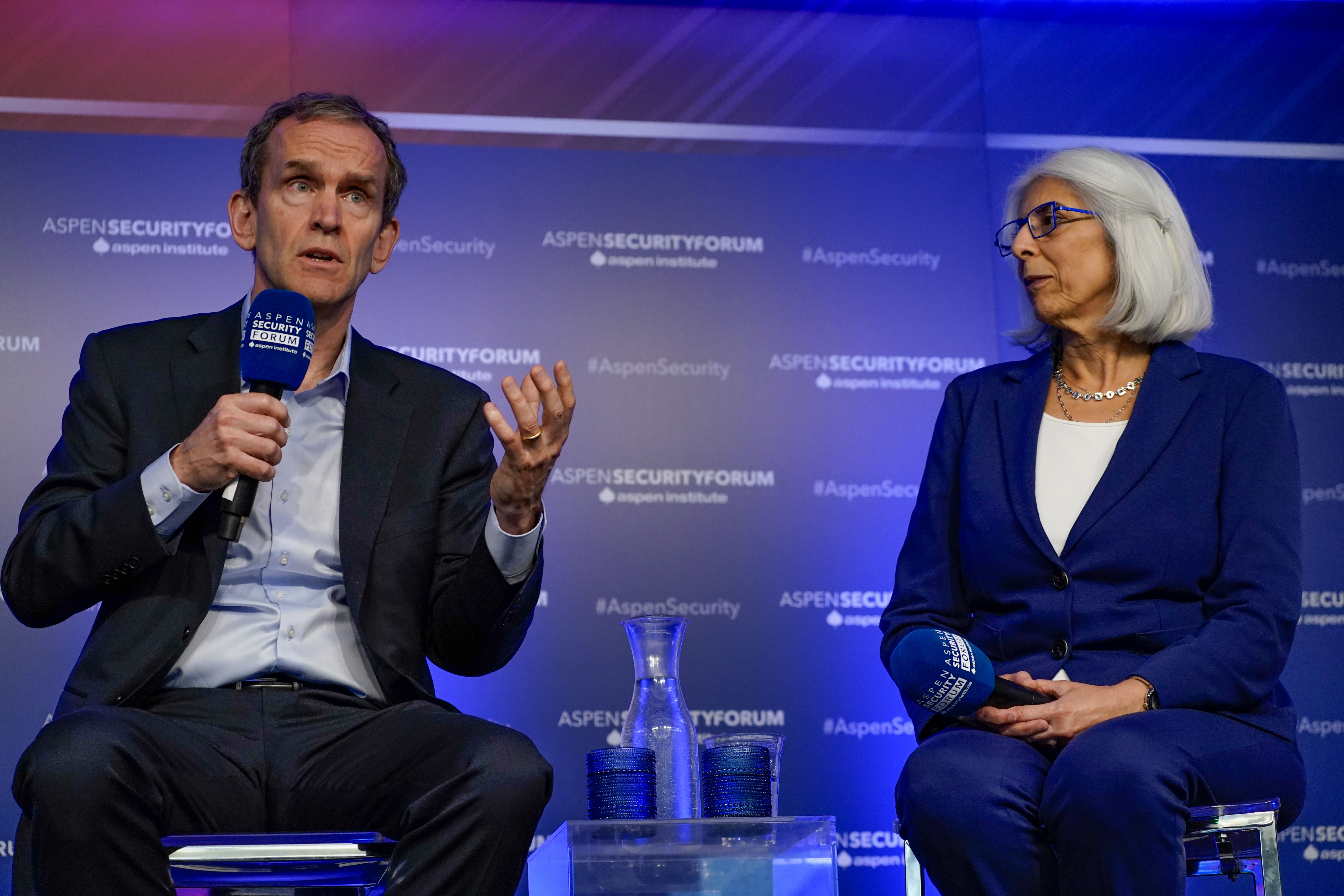 Google's Kent Walker speaks into a microphone next to Dr. Arati Prabhakar, (Director, White House OSTP) during a panel at the Aspen Security Forum.