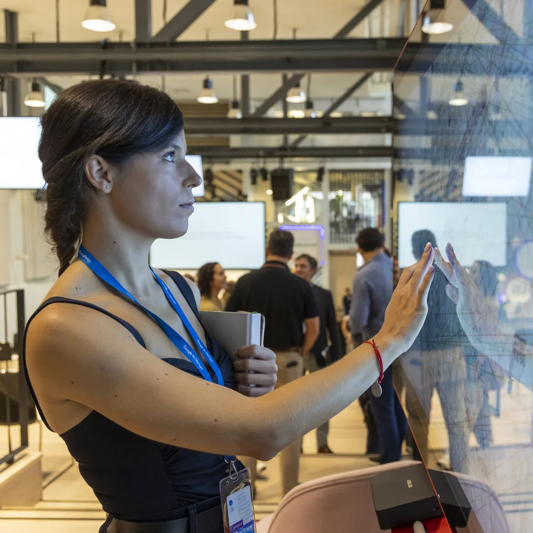 Woman standing touching a large touchscreen TV