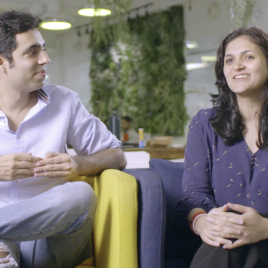 A man and a woman sitting on sofas