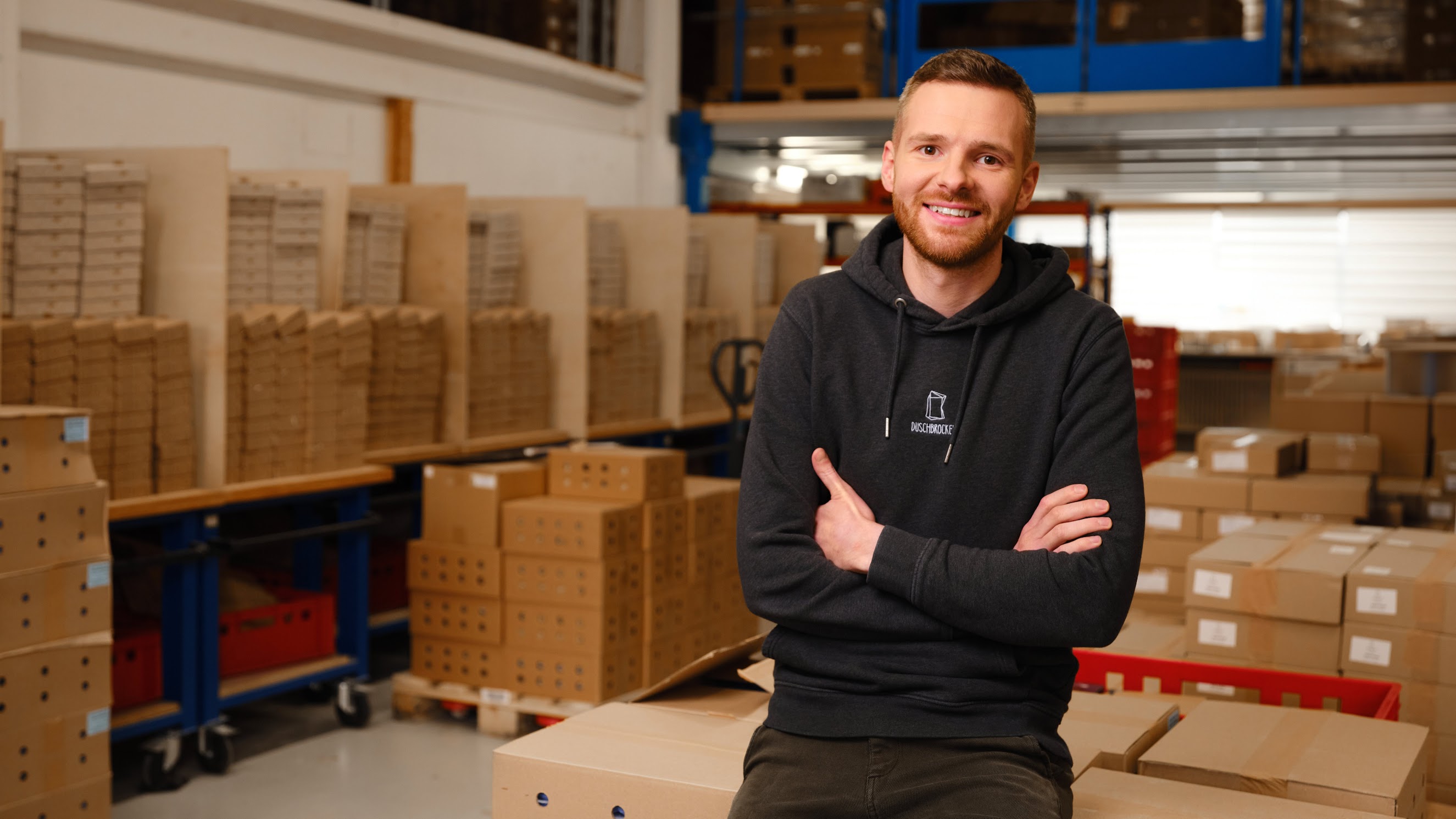 Founder standing in front of company logo