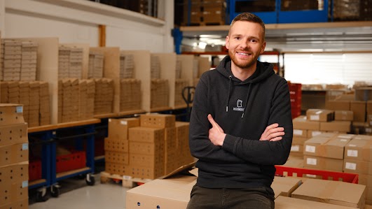 Founder standing in front of company logo