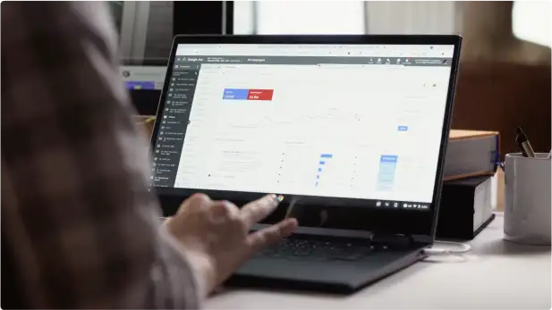 An over the shoulder view of a person using a laptop to manage their Google Ads account.