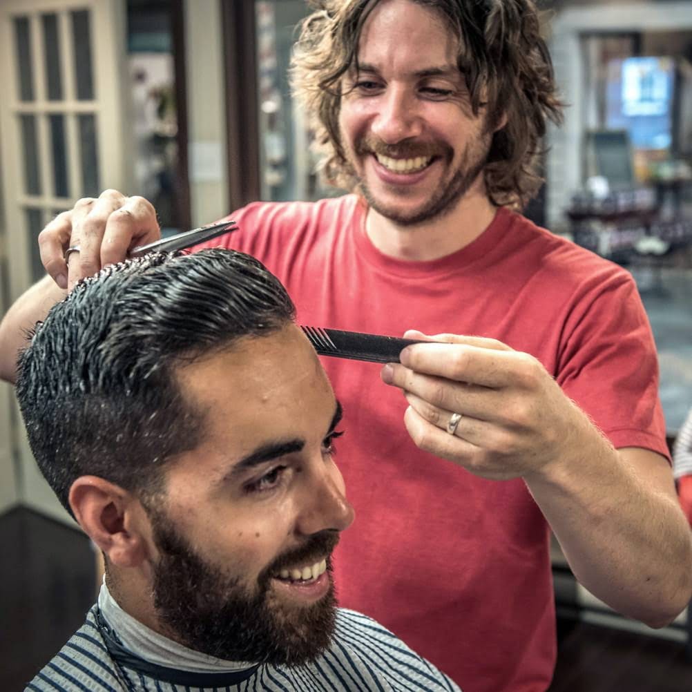 Photo of a barber giving a man a haircut