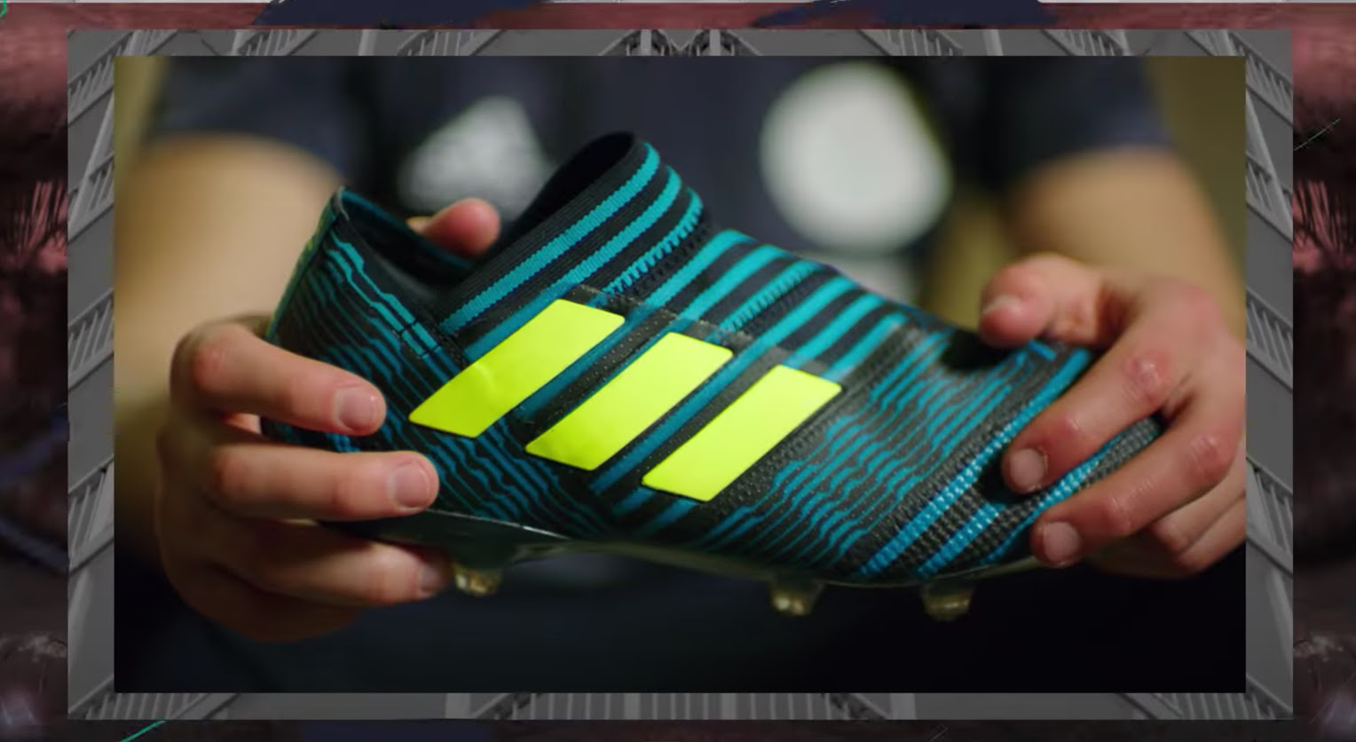 A close-up of hands holding one colorful adidas shoe