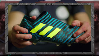 A close-up of hands holding one colorful adidas shoe