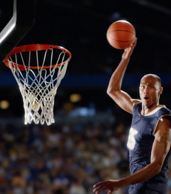 We see a basketball player dunking the ball. 