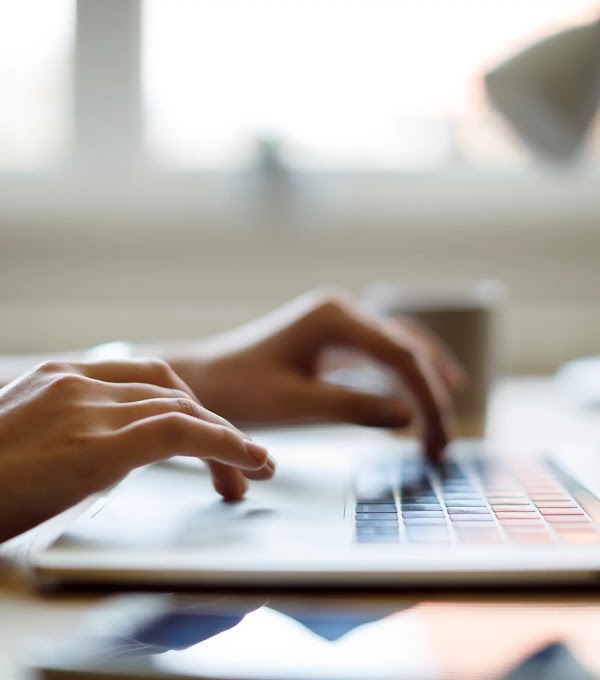 Close up of someone using their laptop while working from home