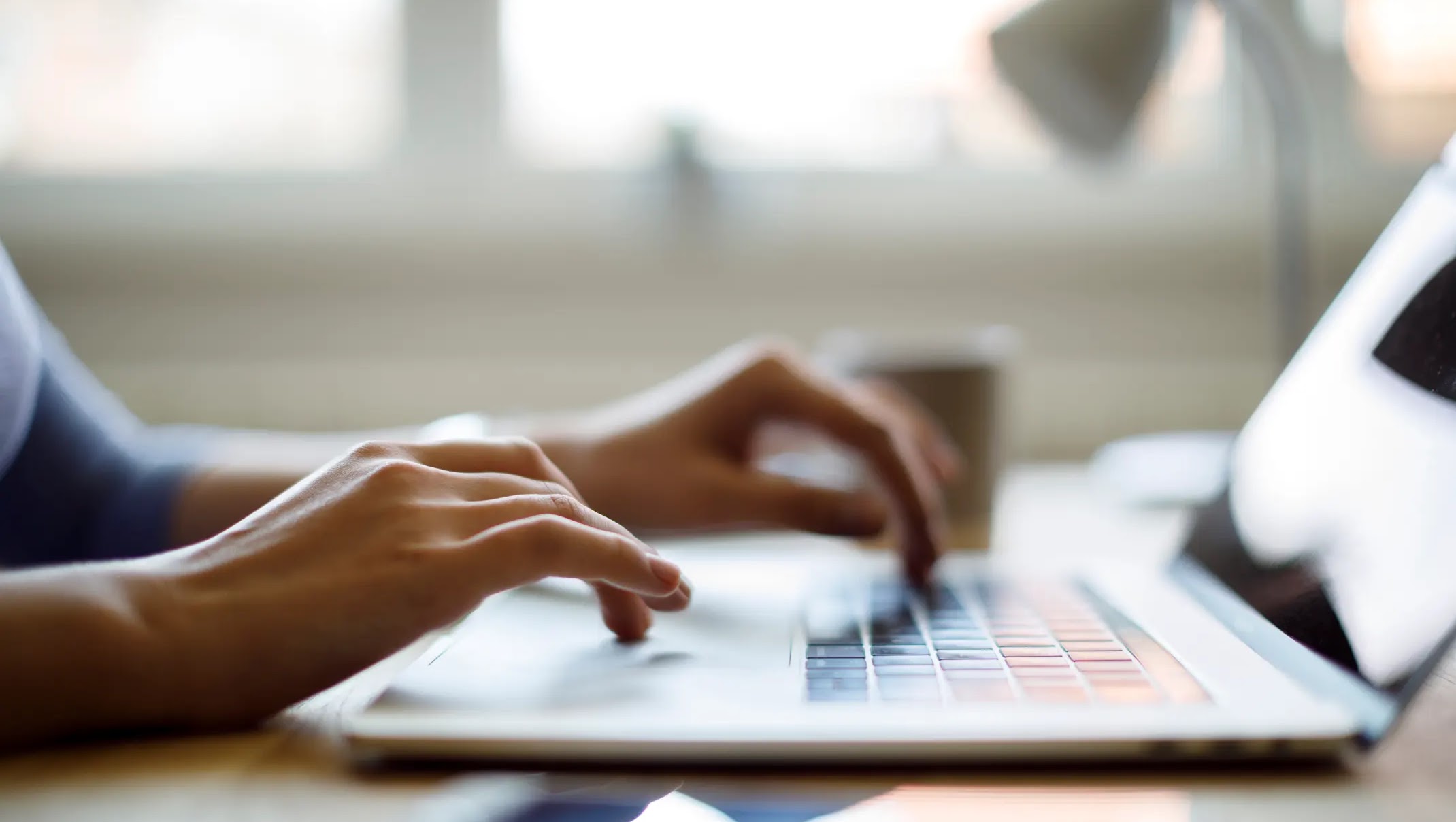 Close up of someone using their laptop while working from home