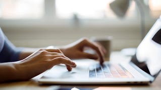 Close up of someone using their laptop while working from home