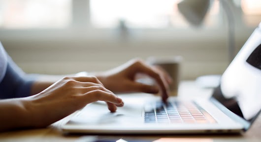 Close up of someone using their laptop while working from home