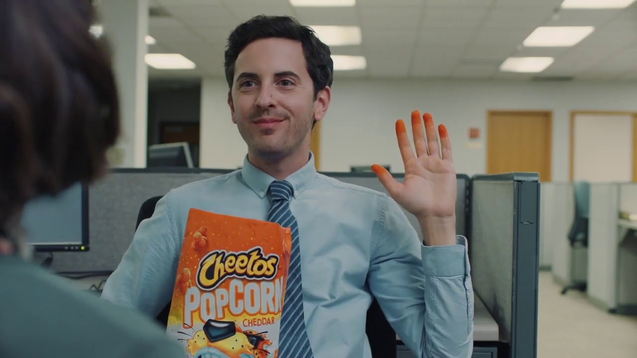 We see a preview for a video with a man holding a bag of Cheetos with a hand covered in Cheetos dust. 