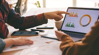 Three teammates  working and discussing business results together in a meeting