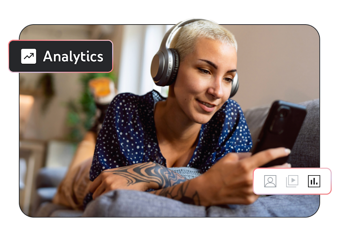 Image of a person wearing headphones, laying on their sofa, and looking at their phone with the word ‘Analytics’ in the corner of the screen.