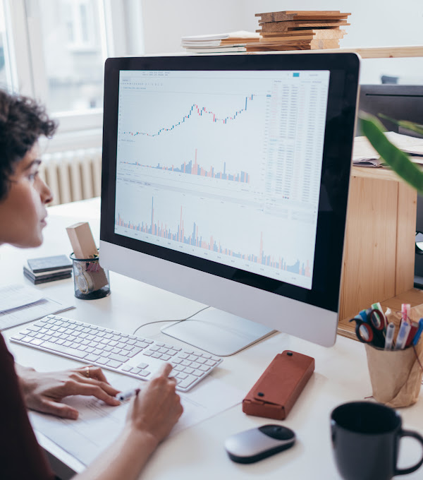 A female marketing expert looking at the screen of a computer and collecting information from the graphs and charts displayed.