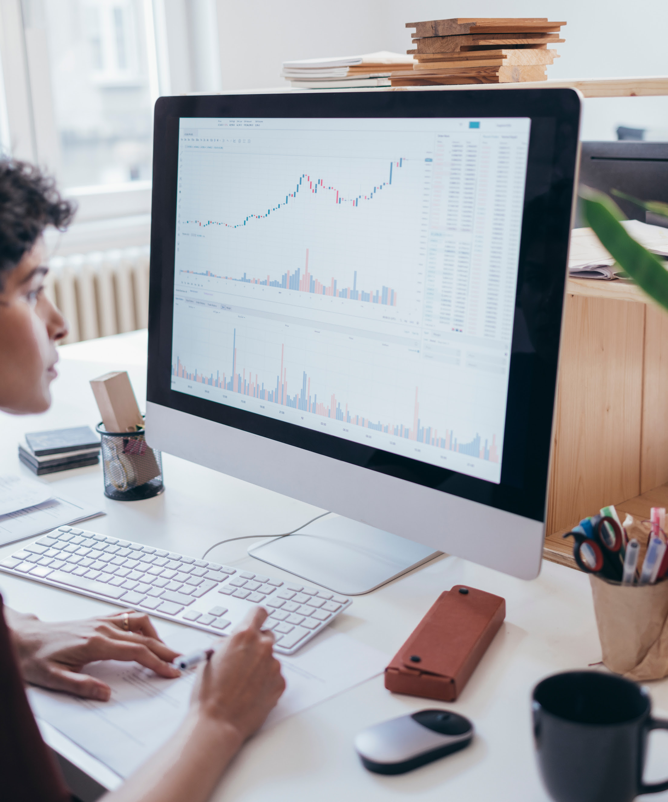 A female marketing expert looking at the screen of a computer and collecting information from the graphs and charts displayed.