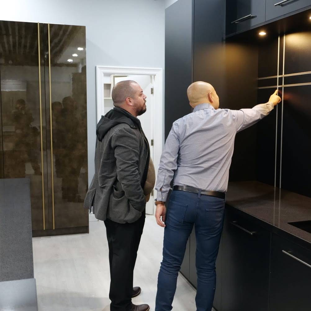 Photo of two men checking out a black kitchen cabinet