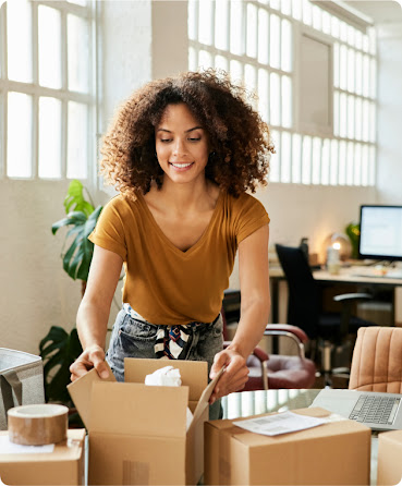 Woman packing up a brown box to ship