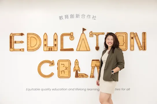 Rachel Huang from Junyi Academy stands in front of organization's sign in Taipei Taiwan