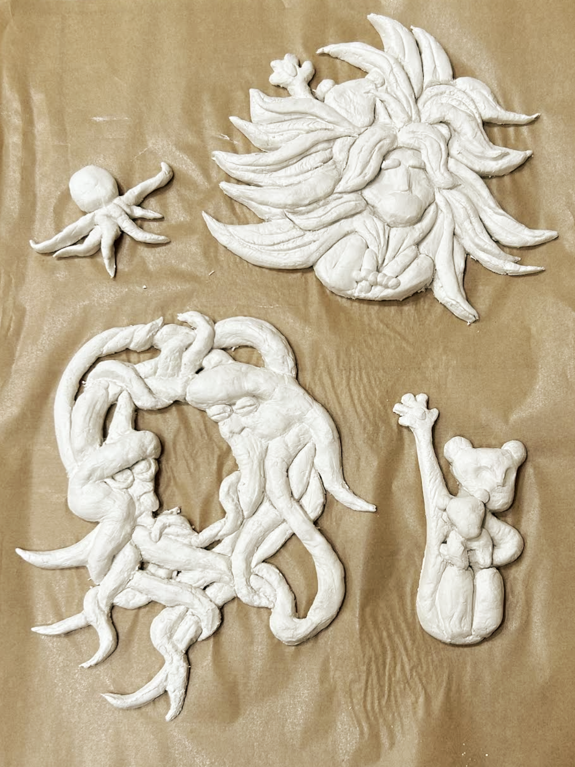 Photograph of four white unpainted clay animals 